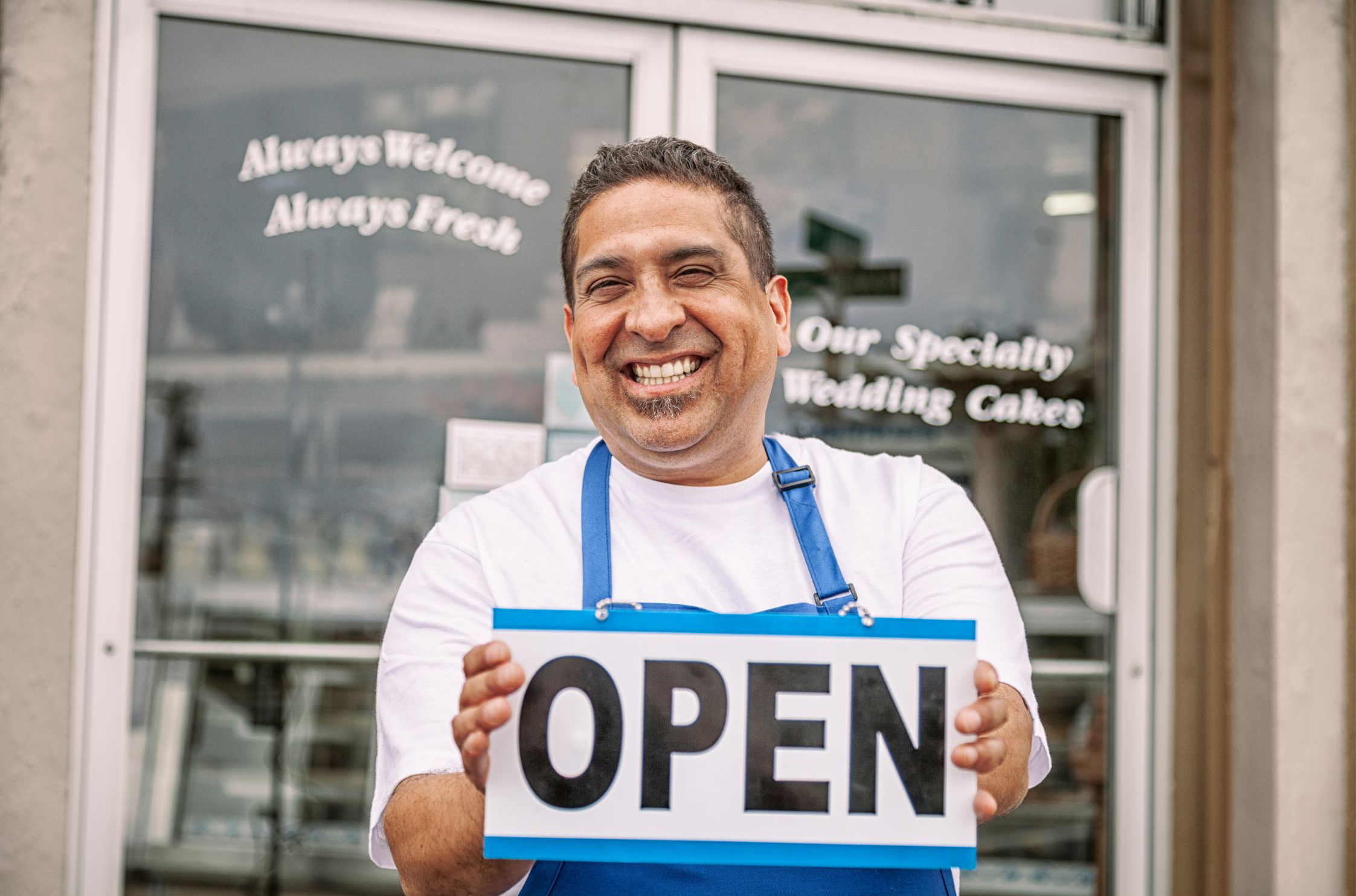 Small business owner at an open sign